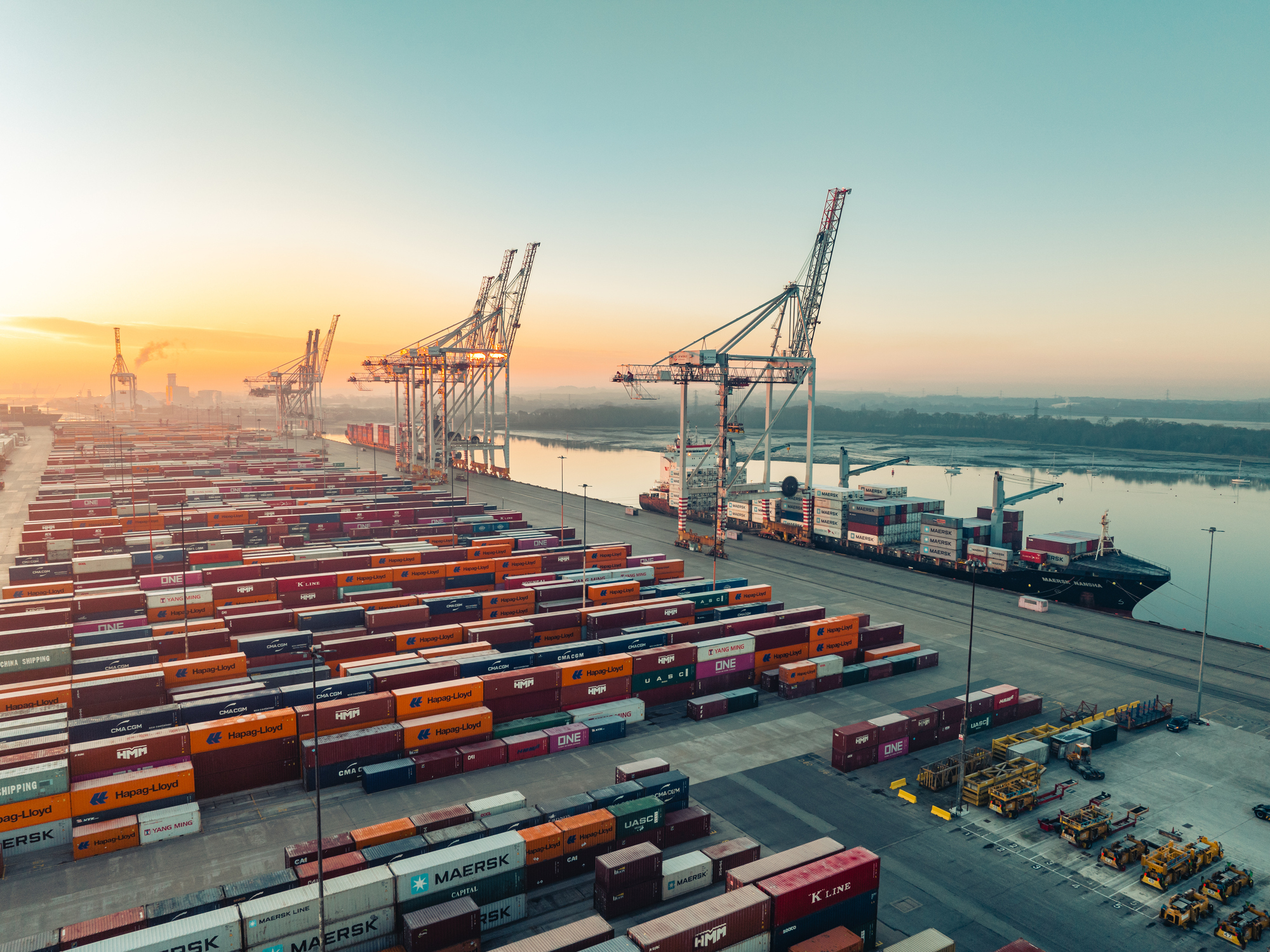 Freight manager with white hardhat looking at the camera with serious face expression